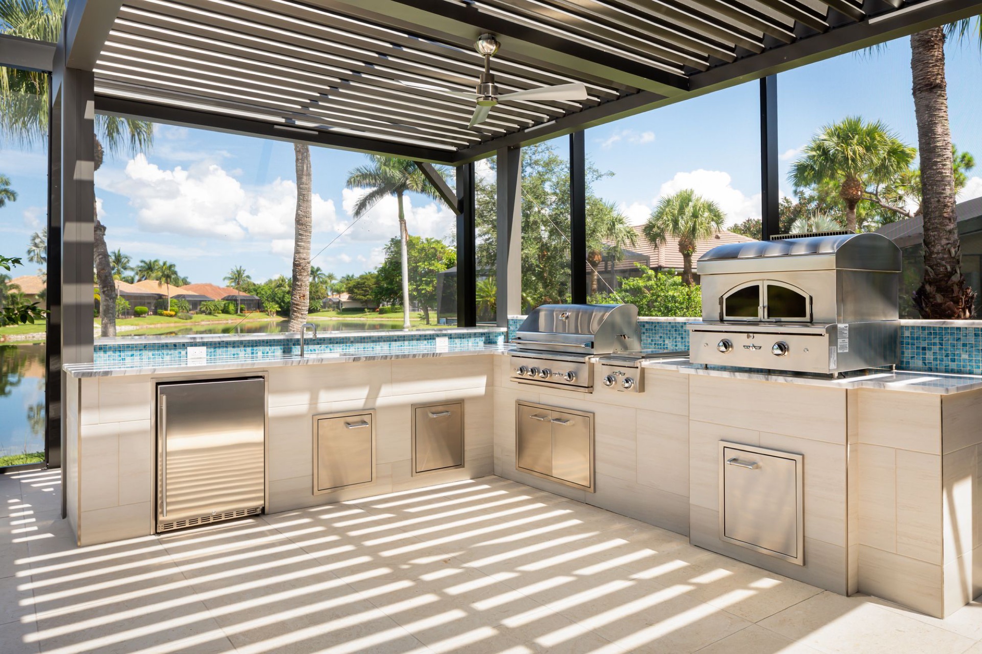 Louvered aluminum pergola over an outdoor kitchen and dining area — Naples, Florida